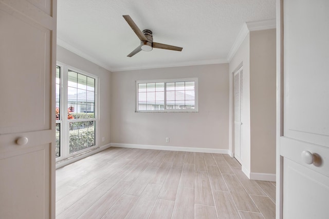 unfurnished room featuring ornamental molding, light wood-type flooring, ceiling fan, and a textured ceiling