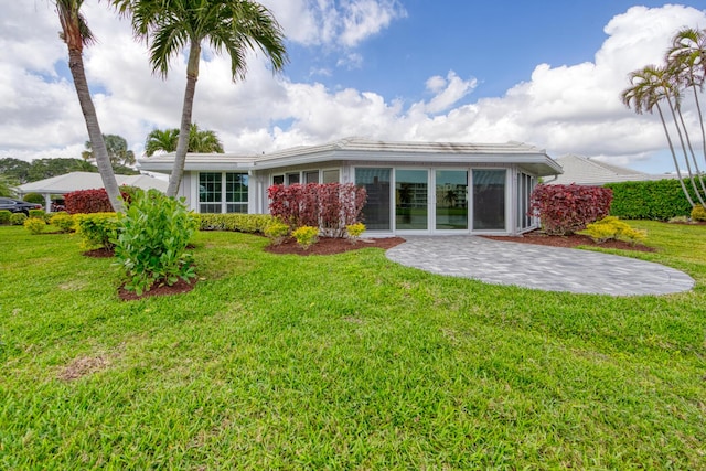 rear view of house featuring a patio and a lawn