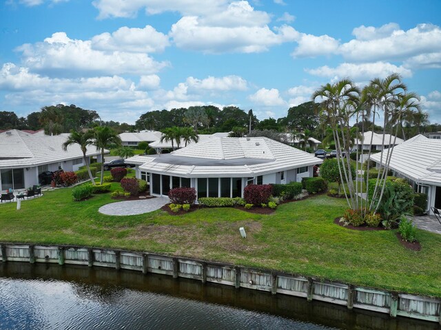 rear view of house with a water view and a yard