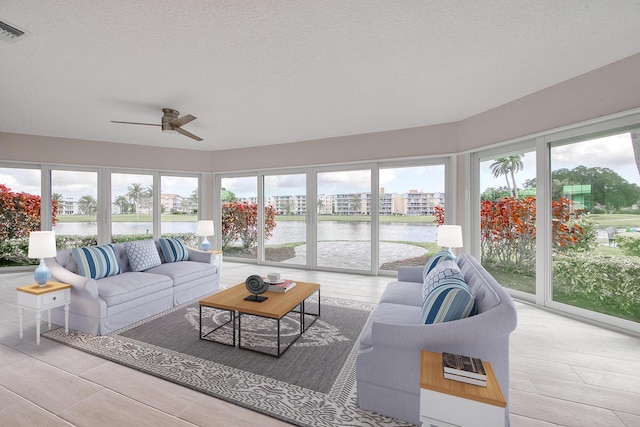 sunroom with a water view and ceiling fan