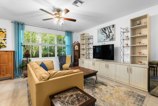 tiled living room featuring a textured ceiling and ceiling fan