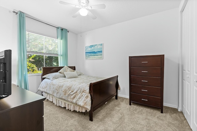 bedroom with light carpet, a closet, and ceiling fan