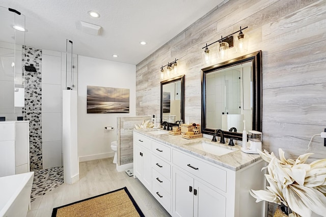 bathroom featuring vanity, a tile shower, and toilet