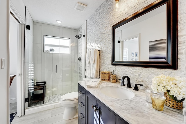 bathroom with vanity, toilet, an enclosed shower, and a textured ceiling