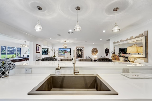 kitchen with crown molding, sink, and hanging light fixtures