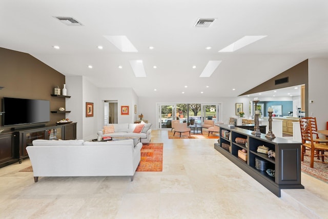 living room with high vaulted ceiling and a skylight