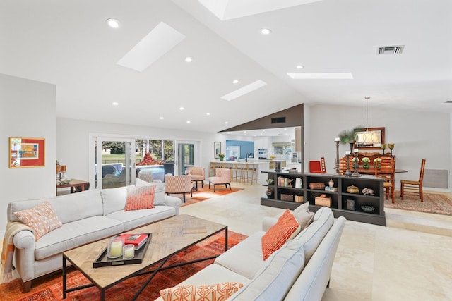 living room with high vaulted ceiling and a skylight