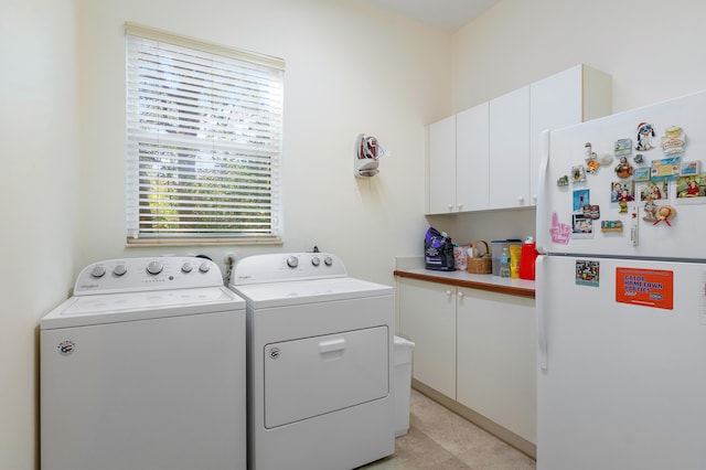 clothes washing area featuring cabinets and washing machine and clothes dryer