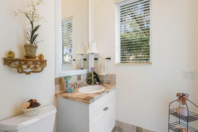 bathroom featuring vanity, toilet, and plenty of natural light