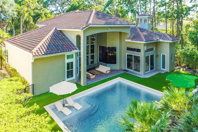 back of house featuring a lawn and a patio area