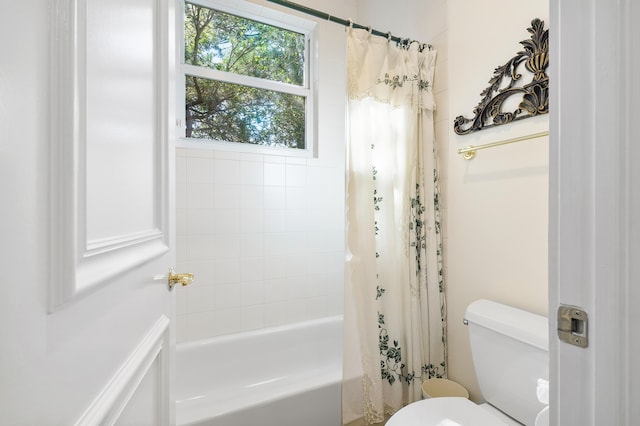 bathroom featuring toilet and shower / bath combo with shower curtain