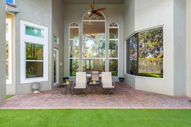 unfurnished sunroom featuring ceiling fan