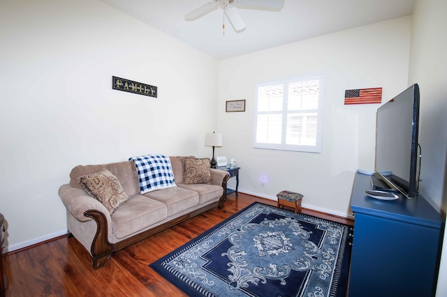 living room featuring dark wood-type flooring and ceiling fan