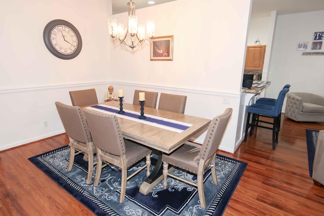 dining area featuring dark wood-type flooring and a chandelier