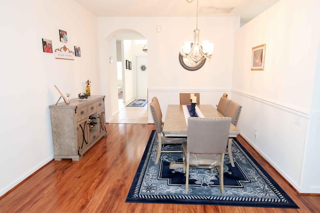 dining area with hardwood / wood-style flooring and a notable chandelier