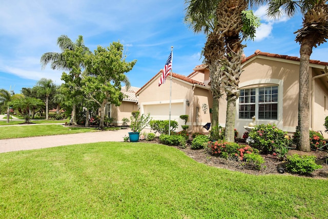 mediterranean / spanish-style house with a garage and a front lawn