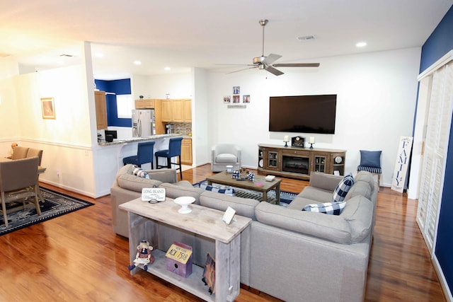 living room featuring wood-type flooring and ceiling fan