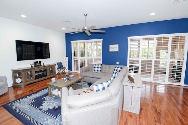 living room featuring hardwood / wood-style floors and ceiling fan