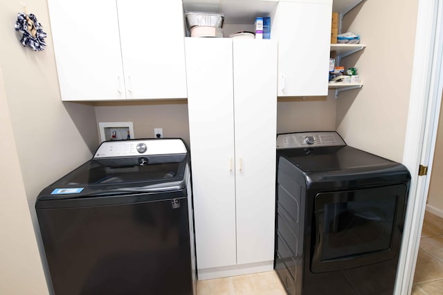 washroom with cabinets, light tile patterned flooring, and washer and dryer