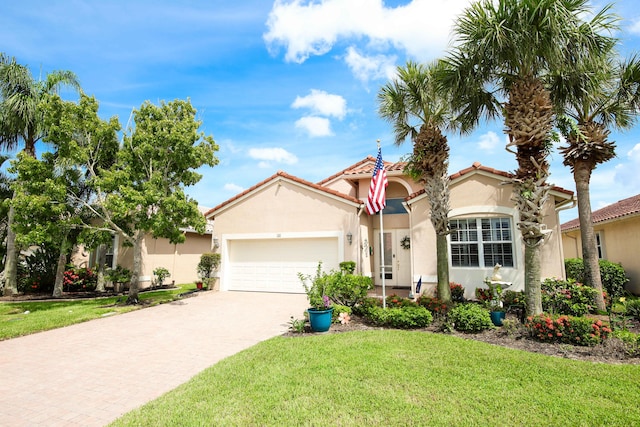 mediterranean / spanish-style house featuring a garage and a front lawn