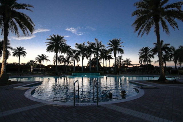 pool at dusk with a patio