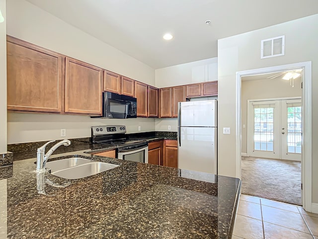 kitchen with refrigerator, sink, dark stone counters, kitchen peninsula, and stainless steel electric range