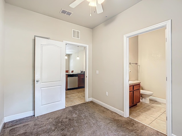 unfurnished bedroom featuring light colored carpet and ensuite bath