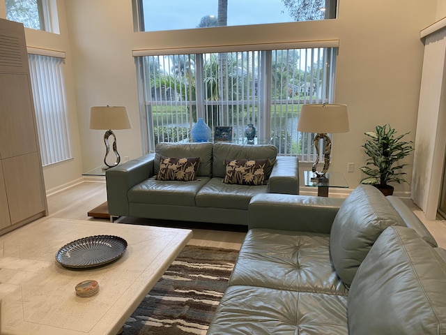 living room with light wood-type flooring and a high ceiling