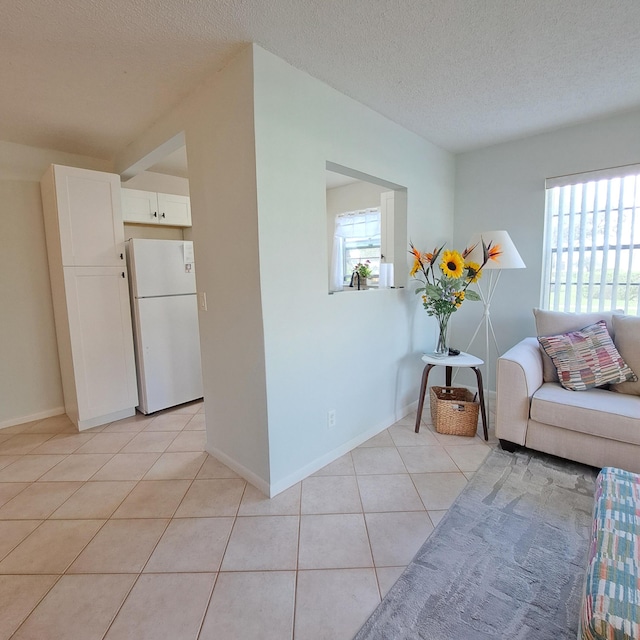 interior space featuring light tile patterned floors and a textured ceiling