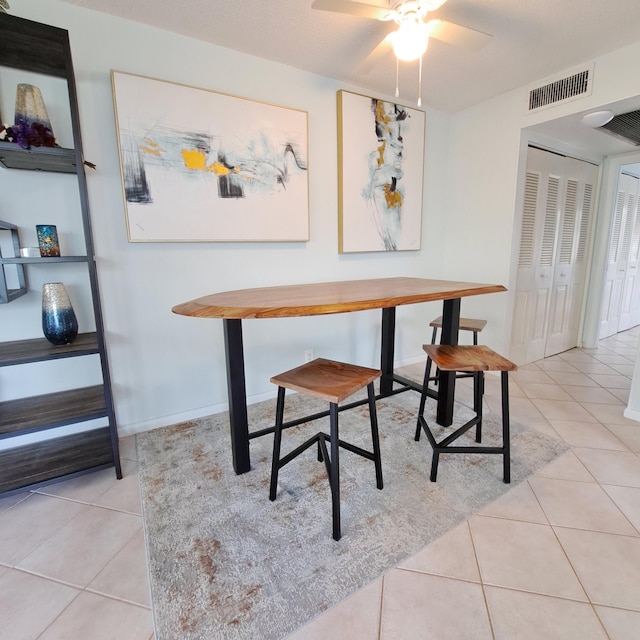 dining space with light tile patterned floors and ceiling fan