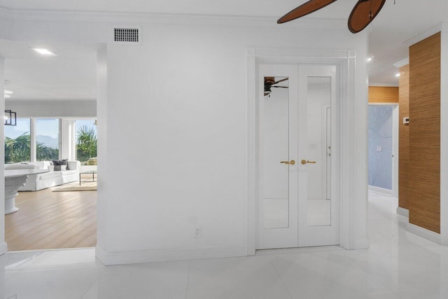 hall featuring baseboards, visible vents, and crown molding