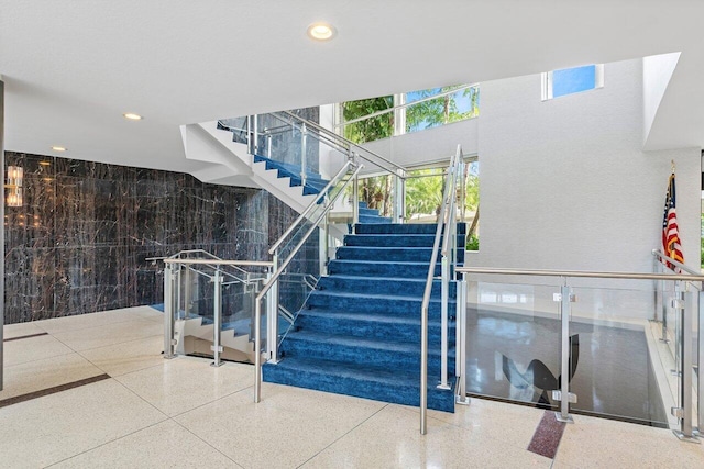 stairway featuring speckled floor and recessed lighting