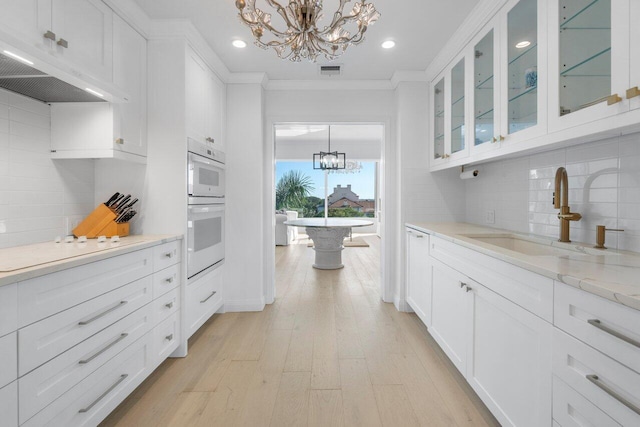 kitchen featuring white cabinetry, glass insert cabinets, and an inviting chandelier