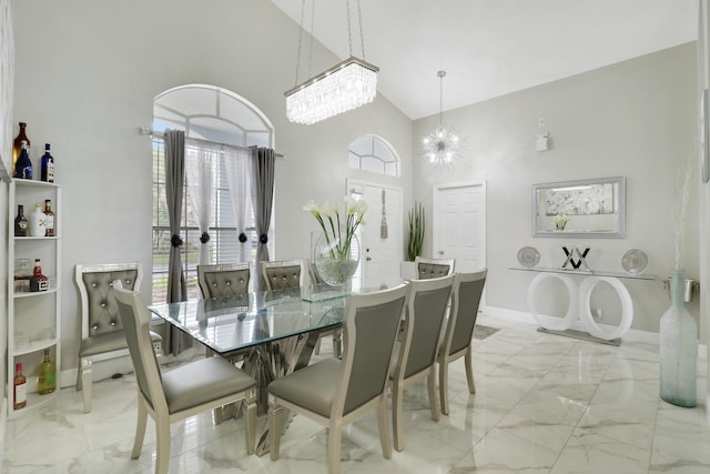 dining area featuring a notable chandelier and a towering ceiling