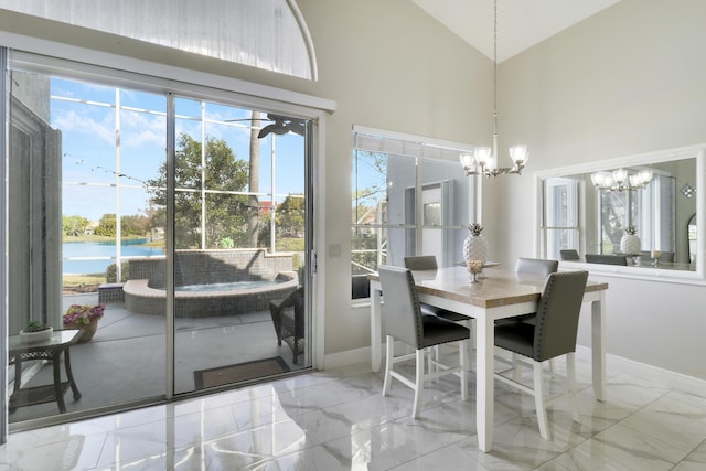 dining area featuring a water view, high vaulted ceiling, and a notable chandelier