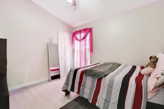 bedroom with ceiling fan, lofted ceiling, and wood-type flooring