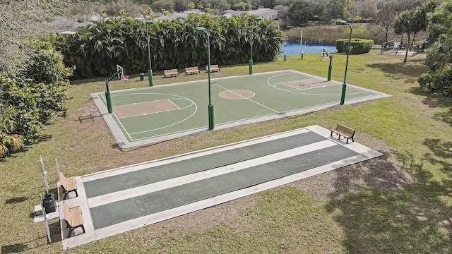 view of basketball court with a lawn and a water view