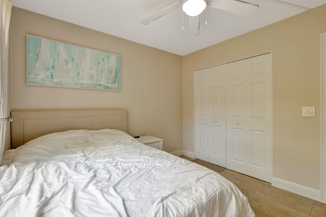 bedroom featuring ceiling fan, a closet, and light tile patterned floors