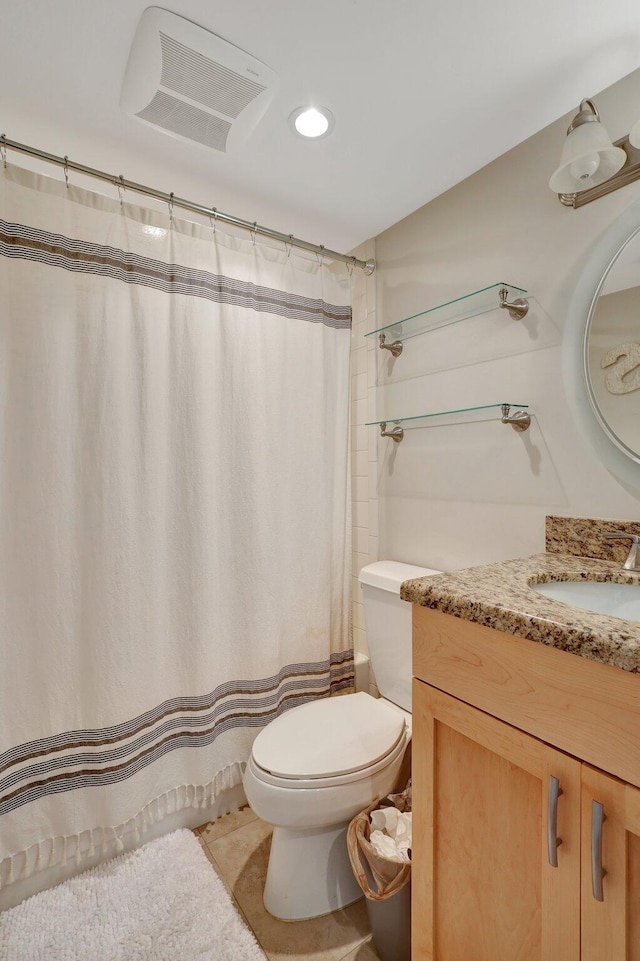 bathroom featuring tile patterned flooring, vanity, curtained shower, and toilet