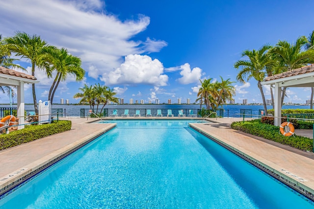 view of pool featuring a water view and a patio area