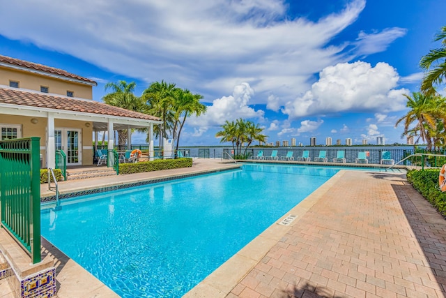 view of swimming pool featuring french doors and a patio