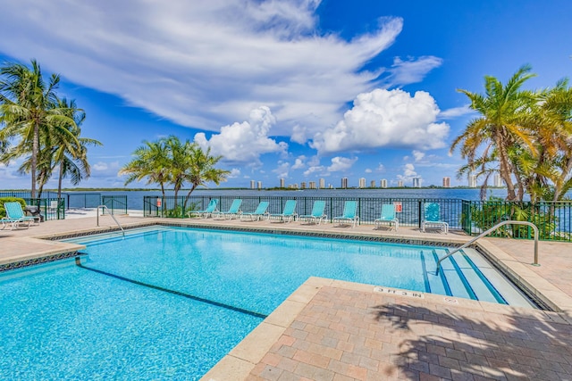 view of swimming pool with a water view and a patio area