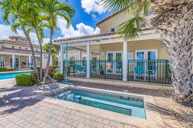 view of pool with a community hot tub, a patio, and french doors