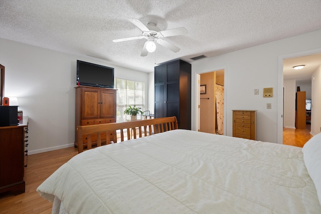 bedroom featuring ceiling fan, a textured ceiling, and light hardwood / wood-style floors