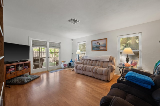 living room featuring french doors and light wood-type flooring