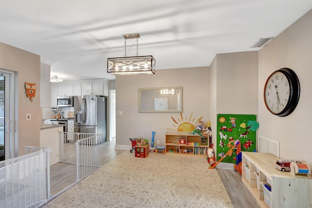 game room with light hardwood / wood-style flooring