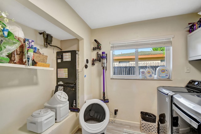 laundry room with cabinets, washing machine and clothes dryer, and light wood-type flooring