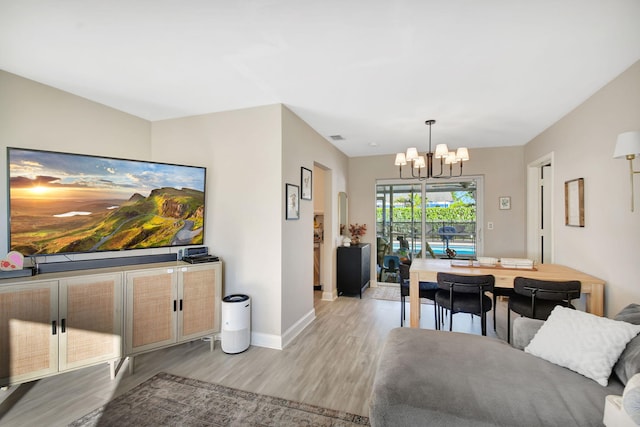 living room with a chandelier and light hardwood / wood-style floors