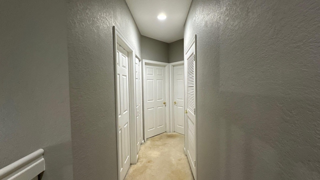 hallway featuring light colored carpet