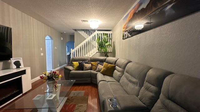 living room with dark wood-type flooring and a textured ceiling